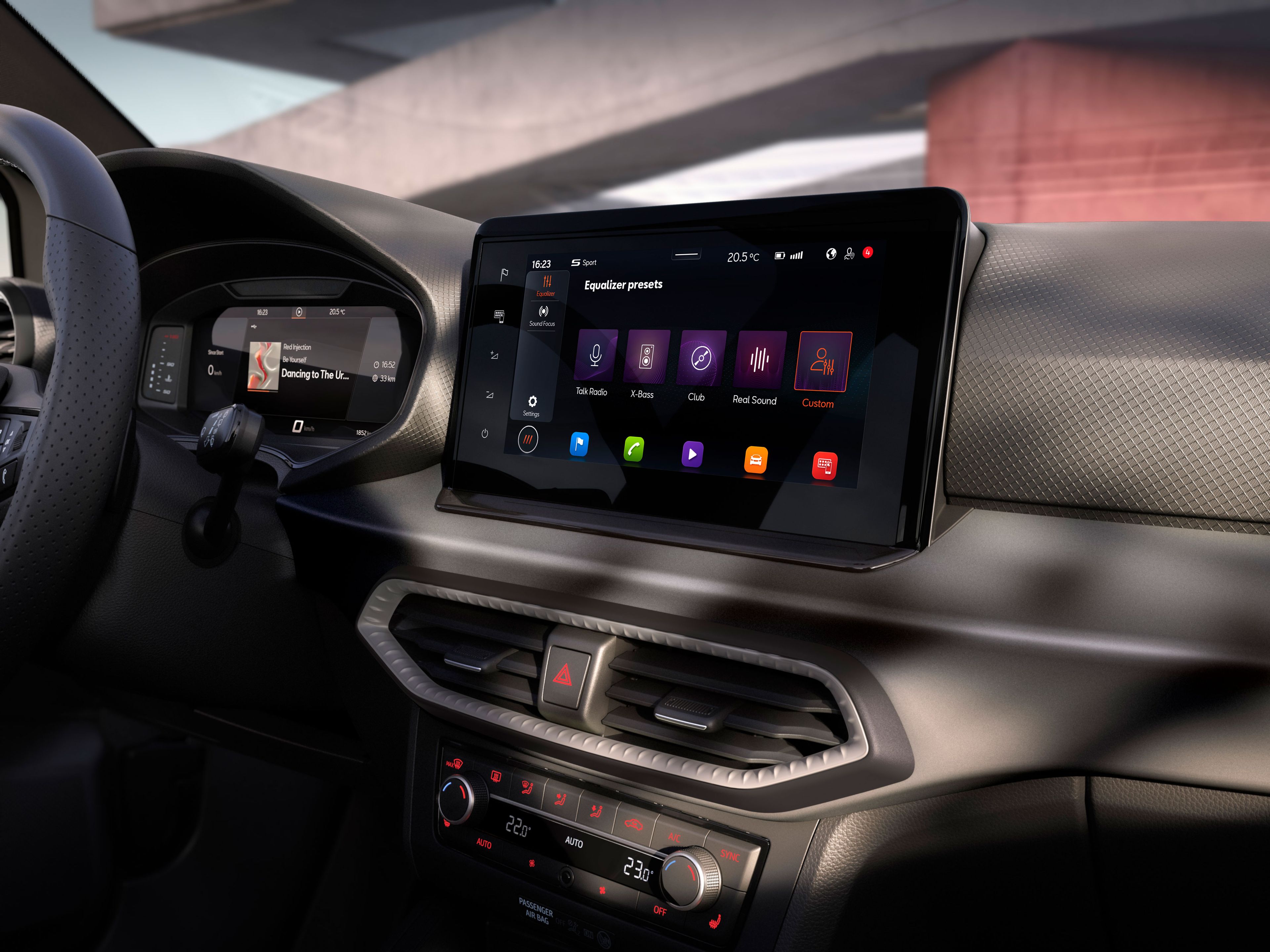 Interiér automobilu s moderným infotainment systémom. Na stredovej konzole je veľký dotykový displej s rôznymi aplikáciami. Na pozadí vidieť časť exteriéru.