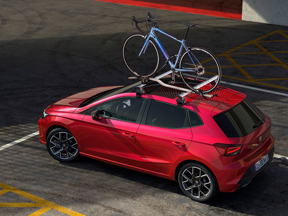 SEAT Ibiza zaparkovaný na parkovacom mieste. Na streche má pripevnený nosič na jeden cestný bicykel.