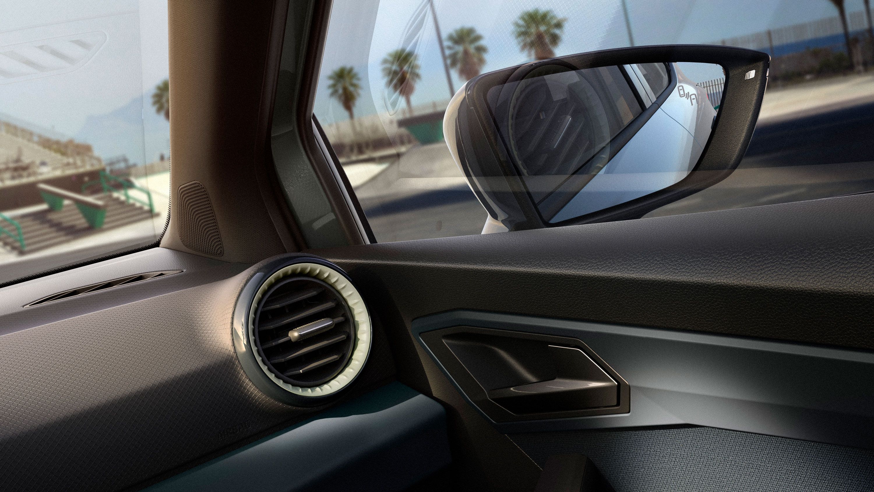 Čiastočný pohľad na interiér vozidla SEAT Arona s niekoľkými detailmi a pravým vonkajším spätným zrkadlom.