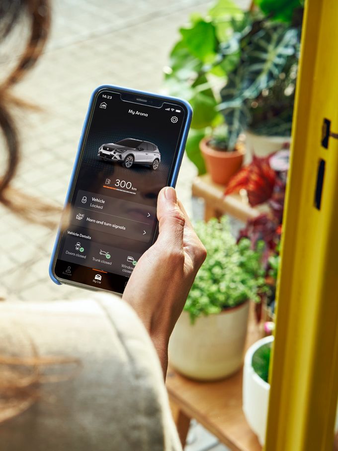 Žena drží v ruke smartfón, na ktorom kontroluje svoje vozidlo prostredníctvom systému SEAT Connect.